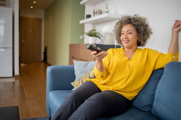 Mujer disfrutando su serie favorita en casa con servicio IPTV en calidad HD