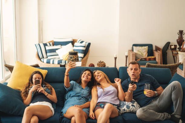 Familia latina viendo televisión en el sofá con servicio IPTV premium