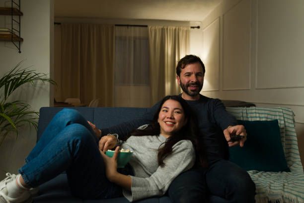 Pareja feliz relajándose viendo televisión con el mejor IPTV disponible